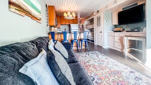 A modern living room with a sofa, chairs, and a TV. - Cozy Beach Condo Sleeps 6 POOL
 (Carolina Beach)