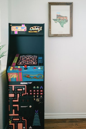 A vintage arcade machine with a Texas map and a framed map on the wall.