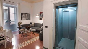 A living room with a sofa, coffee table, and a painting on the wall. - Delightful and elegant apartment in the heart of Palermo. (Palermo)