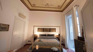 A bedroom with a large bed, two bedside tables with lamps, a ceiling with decorative patterns, and a door with a view to the outside. - Delightful and elegant apartment in the heart of Palermo. (Palermo)