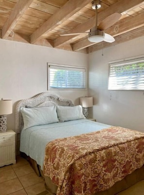 A bedroom with a bed, two bedside tables, a ceiling fan, and two windows with blinds. - Surf, Stay & Play DelMar 200 ft from Beach (Del Mar)