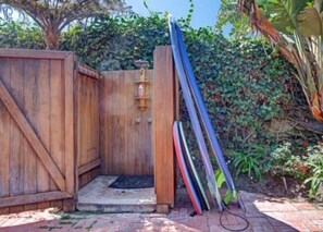 Enter a serene garden oasis with an outdoor space, complete with a doormat and lush greenery.