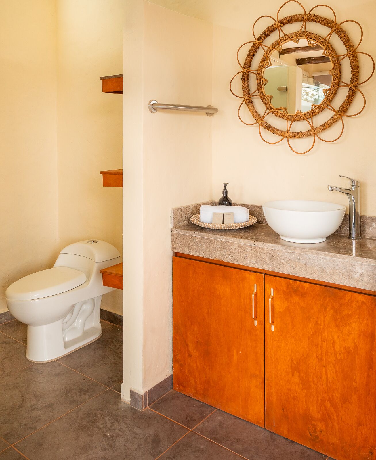 Un baño con inodoro, lavamanos y armarios de madera.