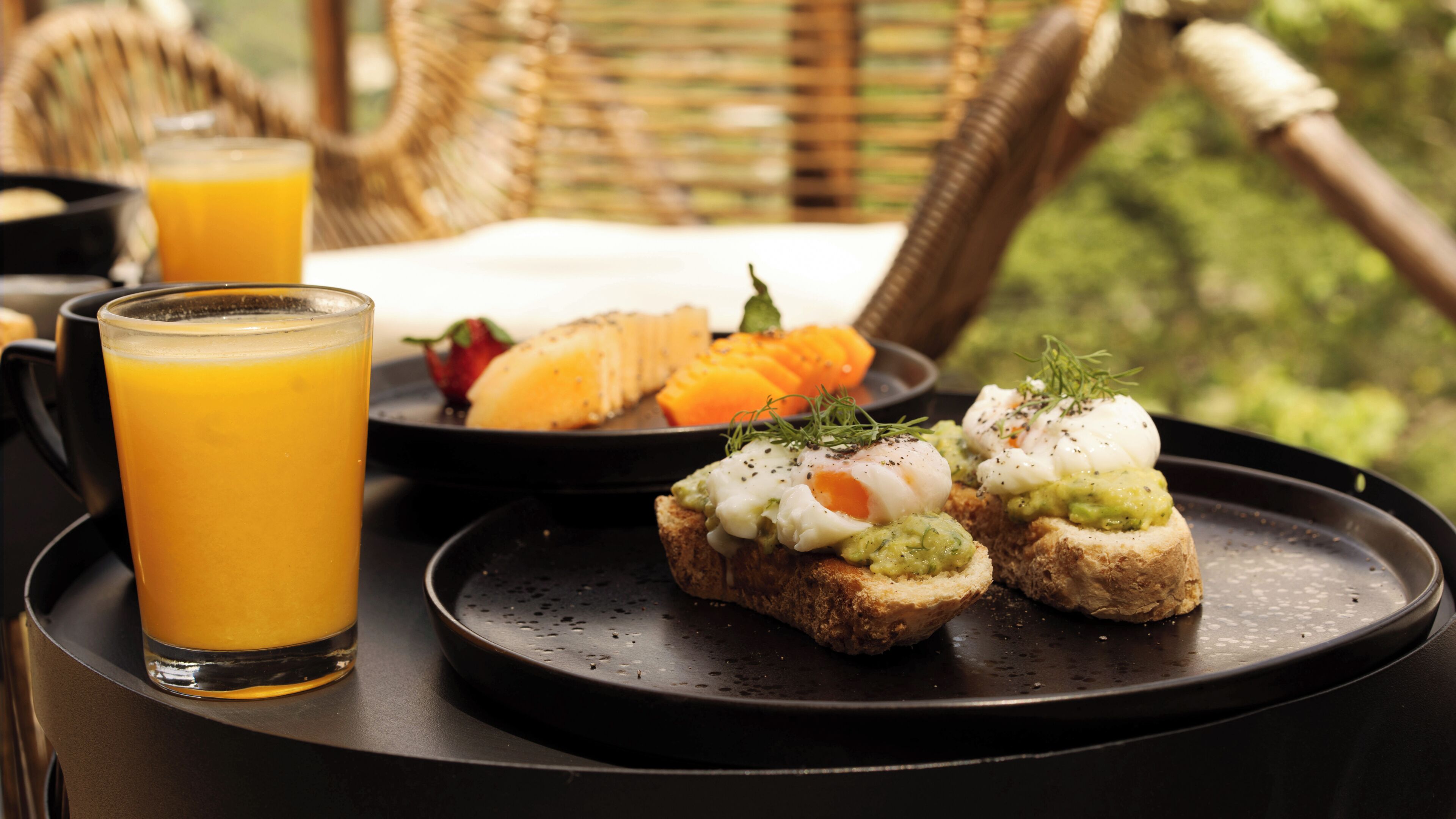 A breakfast tray with toast, poached eggs, and a glass of orange juice.