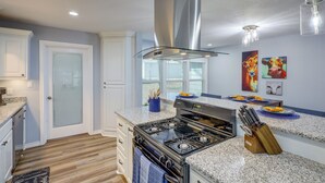 A modern kitchen with granite countertops, stainless steel appliances, and a large island.