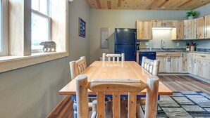 A wooden dining table with chairs, a kitchen with wooden cabinets, and a refrigerator. - Cozy Lake Wissota Escape w/ Community Dock! (Chippewa Falls)
