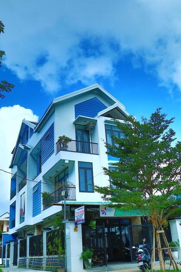 A multi-story building with a modern architectural design, featuring balconies and large windows.