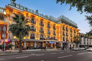 A multi-story hotel with a classic architectural style, featuring arched windows and balconies.