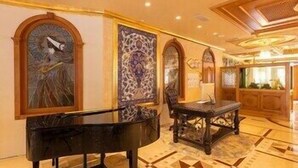 A grand lobby with a grand piano, ornate wall decorations, and a patterned floor. - Wyndham Istanbul Old City (Istanbul)
