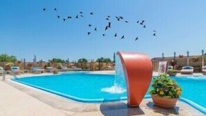 A swimming pool with a curved structure and a potted plant. - Wyndham Istanbul Old City (Istanbul)