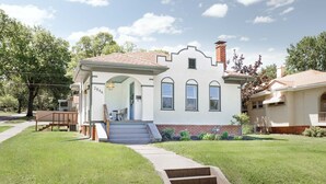 A single-story house with a front porch, a chimney, and a small front yard. - Welcome to Casa de Campo! Your Home Away From Home (Saint Joseph)