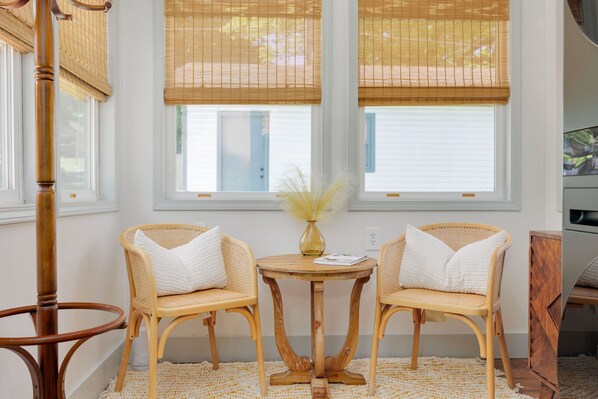 A room with two wicker chairs, a round wooden table, and a vase with dried plants. - Welcome to Casa de Campo! Your Home Away From Home (Saint Joseph)
