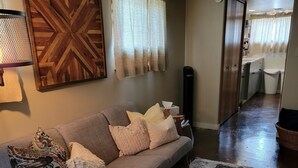 Un salon avec un canapé, une table basse et un tapis à motifs.