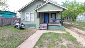 A small, single-story house with a porch, a blue door, and a number '2105' on the front. - Cozy private cottage only 2 miles to downtown & ATT center  (San Antonio)