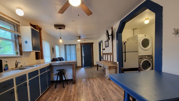 A kitchen with wooden flooring, a dining table, a ceiling fan, and a built-in washing machine. - Cozy private cottage only 2 miles to downtown & ATT center  (San Antonio)