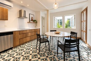 A modern kitchen with a dining area, featuring a patterned floor, wooden cabinets, and a built-in dishwasher. - Beautiful and spacious 3 bedrooms in the Old Town with balcony (Ciudad de Panamá)