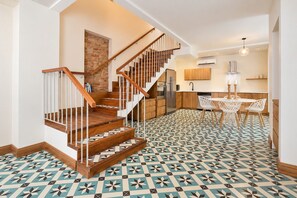 A modern kitchen with a central island, wooden staircase, and patterned floor tiles. - Beautiful and spacious 3 bedrooms in the Old Town with balcony (Ciudad de Panamá)