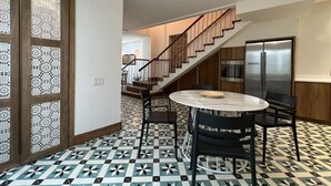 A modern kitchen with a round marble table, black chairs, and a stainless steel refrigerator. - Beautiful and spacious 3 bedrooms in the Old Town with balcony (Ciudad de Panamá)