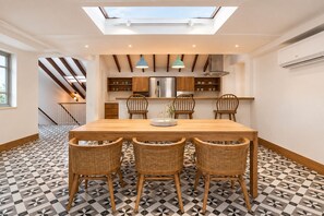 A modern kitchen with a skylight, wooden cabinets, and a dining area with a patterned floor. - Rooftop Private Terrace + Spacious 1BR @CascoViejo (Ciudad de Panamá)