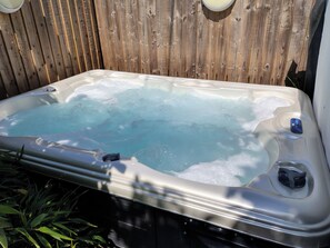 A hot tub with a wooden fence in the background. - Avonmede (Tewkesbury)