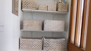 A storage area with shelves holding wicker baskets and a large woven basket. - Downtown Snoqualmie Home - Hot Tub, Fully Fenced Yard - Pet Friendly! (Snoqualmie)