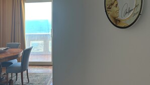 A dining area with a table and chairs, a decorative plate on the wall, and a view through an arched doorway. - Modern and bright apartment located on the Catania waterfront. (Catania)