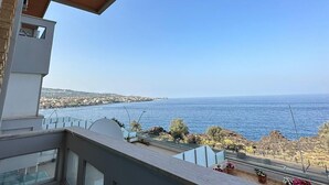 A balcony with a view of the sea and a distant coastline. - Modern and bright apartment located on the Catania waterfront. (Catania)