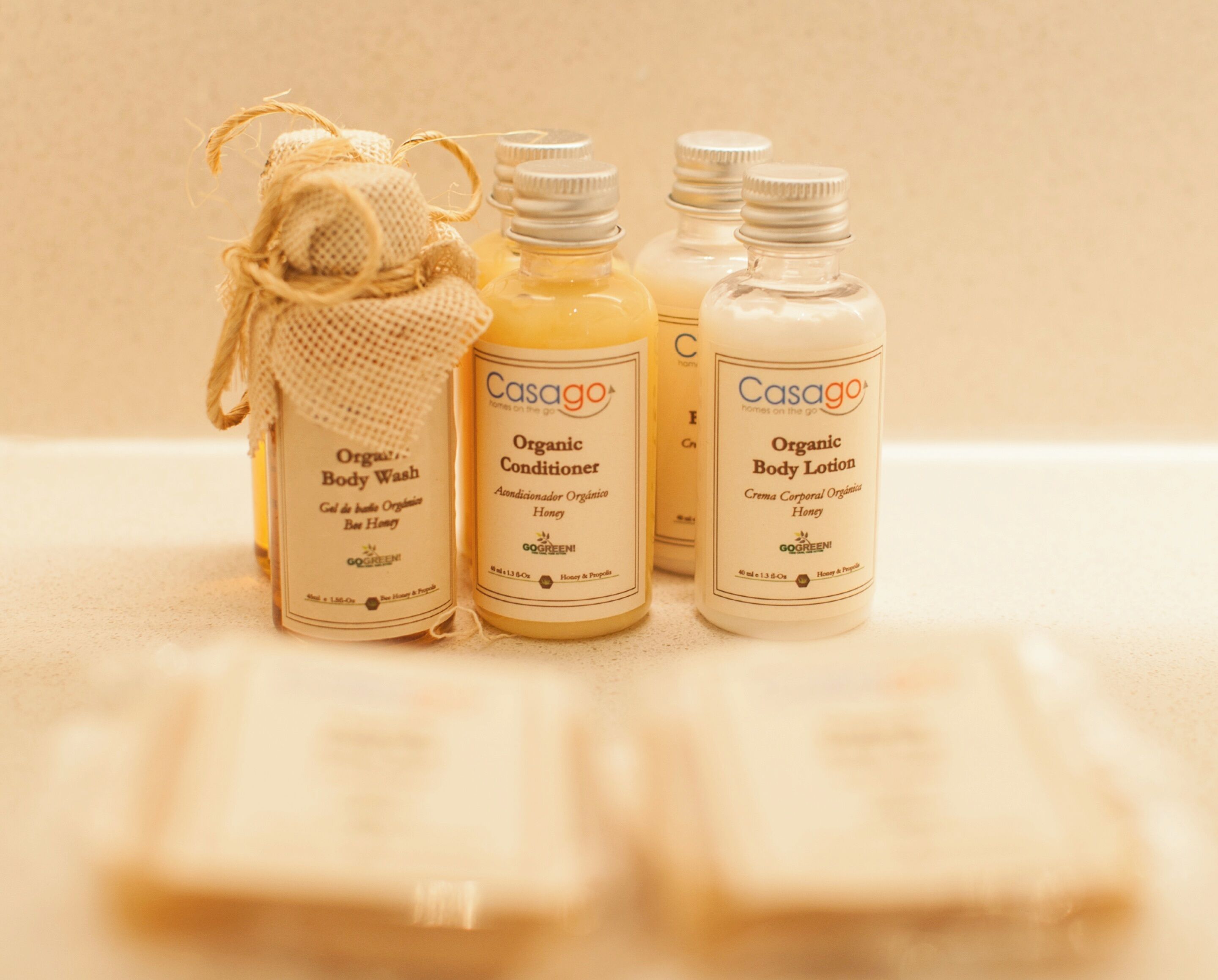 Three bottles of organic body wash and lotion, and a small burlap sack.