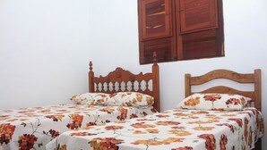 Ein Schlafzimmer mit zwei Einzelbetten, jeweils mit Holz Kopfteil und blumigem Bettzeug.