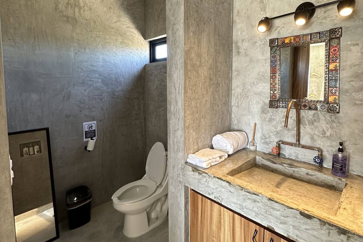 A bathroom with a toilet, sink, and shower area.