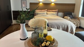 Un dormitorio moderno con cama, mesita de noche y una decoración que incluye un florero, botellas y un frutero.