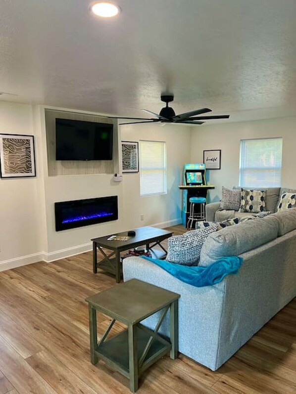 Una sala de estar con un sofá, una mesa de centro, un televisor y una chimenea.