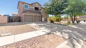 A two-story house with a garage, a fenced driveway, and a well-maintained lawn with a tree. - Aris Oasis  Private Pool Heat Included (Gilbert)