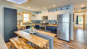 A modern kitchen with a wooden table, built-in appliances, and a view to the outside. - Waterfront Lodi Vacation Rental on Lake Wisconsin! (Lodi)