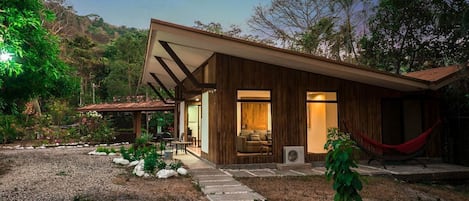 A modern house with a wooden exterior, a covered patio, and a hammock.