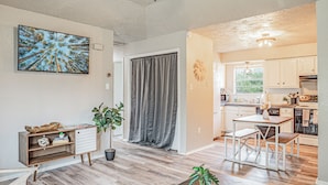 A modern kitchen with white cabinets, a dining table, and a view of the outdoors. - This house is a 2 bedroom(s), 1 bathrooms, located in Abilene, TX. (Abilene)