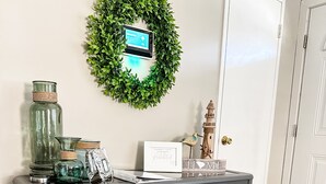 Une console avec des bacs de rangement, une tablette et des objets décoratifs, le tout placé contre un mur.