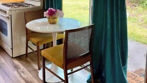 A kitchen with wooden cabinets, a white stove, and a round table with chairs. - The Gemini (Elkhart)