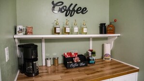 Un espace dédié au café, comprenant une machine à café, des distributeurs et un comptoir à café, le tout installé sur un plan de travail en bois.