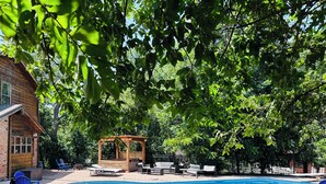 A backyard with a swimming pool, a wooden gazebo, and outdoor seating. - Lake Oasis w/Pool, Hot tub, Gym (Warr Acres)