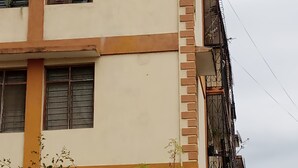 Ein mehrstöckiges Gebäude mit beiger Fassade, braunen Verzierungen und zahlreichen Fenstern.
