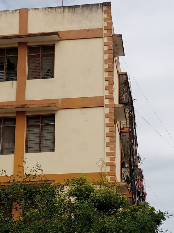 Un edifici de diverses plantes amb façana beix, adorns marrons i nombroses finestres.