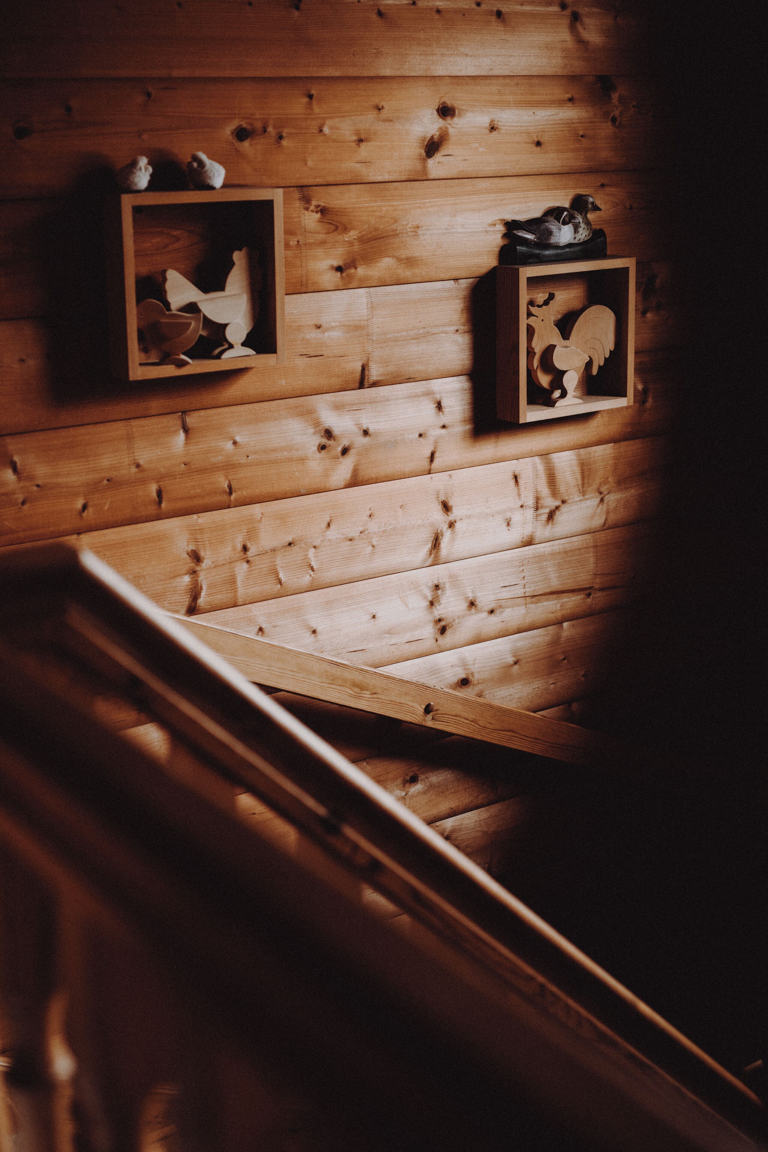 A wooden interior with two framed wooden carvings on the wall.