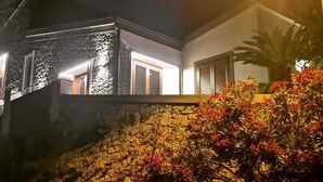 A modern house with a stone facade and a well-lit entrance.