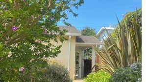 A pathway leading to a house with a covered porch, surrounded by various plants and shrubs. - FUN at the beach and park with Family & Friends! (Santa Barbara)