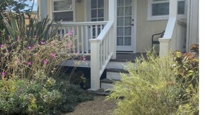 A single-story house with a covered porch, a front door, and a small front yard with gravel and plants. - FUN at the beach and park with Family & Friends! (Santa Barbara)