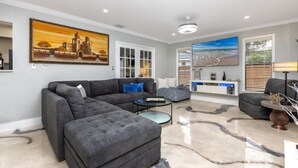A modern living room with a sectional sofa, a coffee table, and a TV unit. - Paradise in Clearwater (Clearwater)