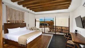 A modern hotel room with a large bed, wooden flooring, a balcony with a view, and a desk with a chair. - Jungle Retreat with Private Tub & Cenote (Tulum)