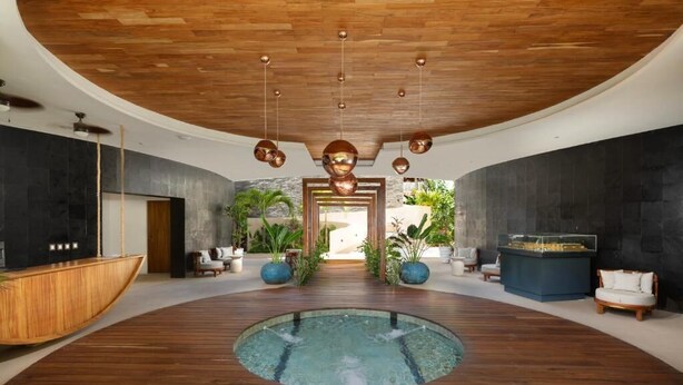 A spacious indoor area with a central pool, wooden flooring, and modern furnishings. - Jungle Retreat with Private Tub & Cenote (Tulum)