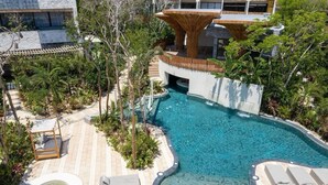 A pool area with a hot tub, lounge chairs, and a waterfall feature. - Jungle Retreat with Private Tub & Cenote (Tulum)